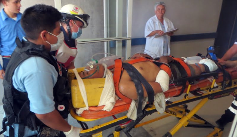 Queda prensado en cajas de tráiler y podría perder las piernas