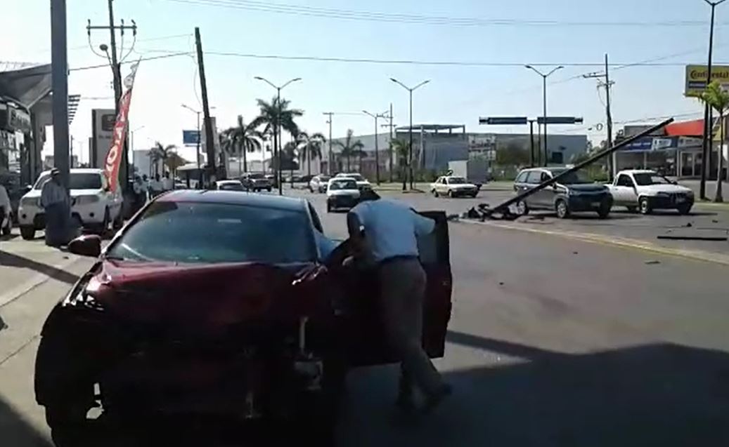 Derriba poste y casi choca con automóviles de agencia (VIDEO)