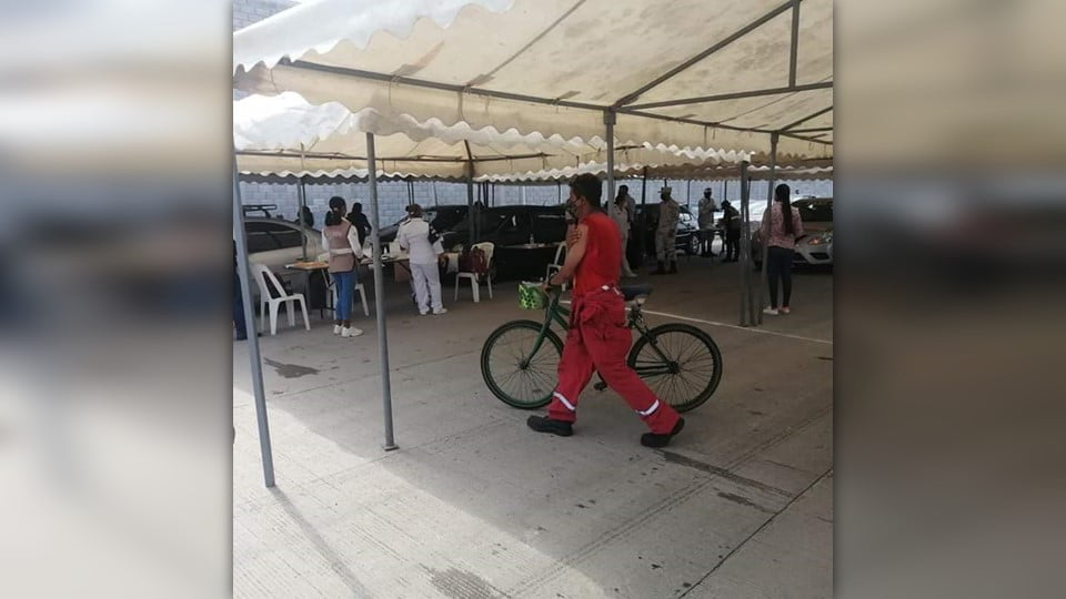 A bordo de su bicicleta, obrero de Altamira recibe su primera dosis de vacuna anticovid.