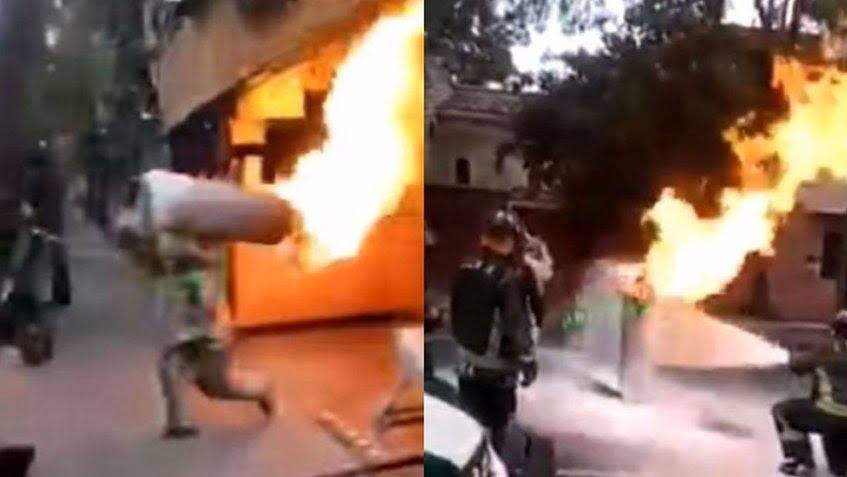 Bombero carga tanque de gas en llamas y evita explosión