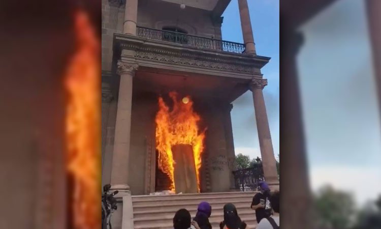 Exigen justicia por feminicidios, incendian puerta de palacio de gobierno en NL