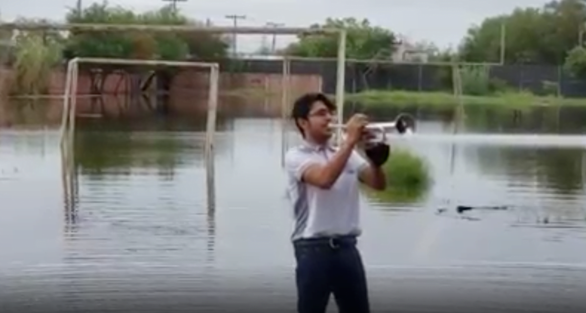 ¡Ve el lado positivo! Joven toca la trompeta en medio de escuela inundada