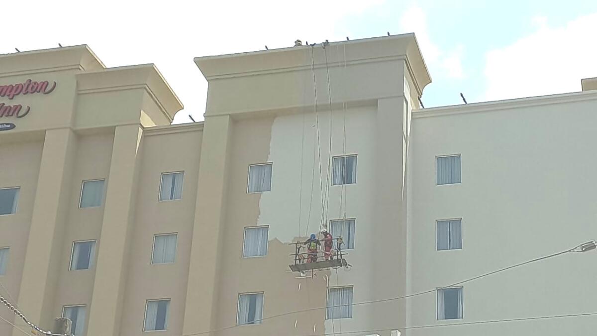 Quedan atrapados en andamio al pintar fachada de hotel